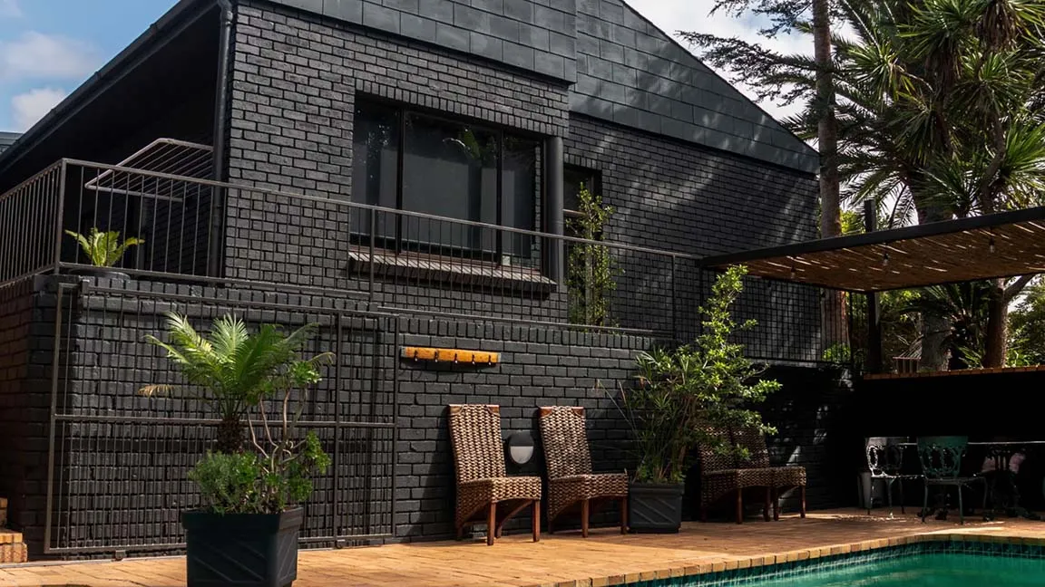 Completed Renov8 home renovation in Aurora, Durbanville, with charcoal brickwork and a landscaped pool terrace