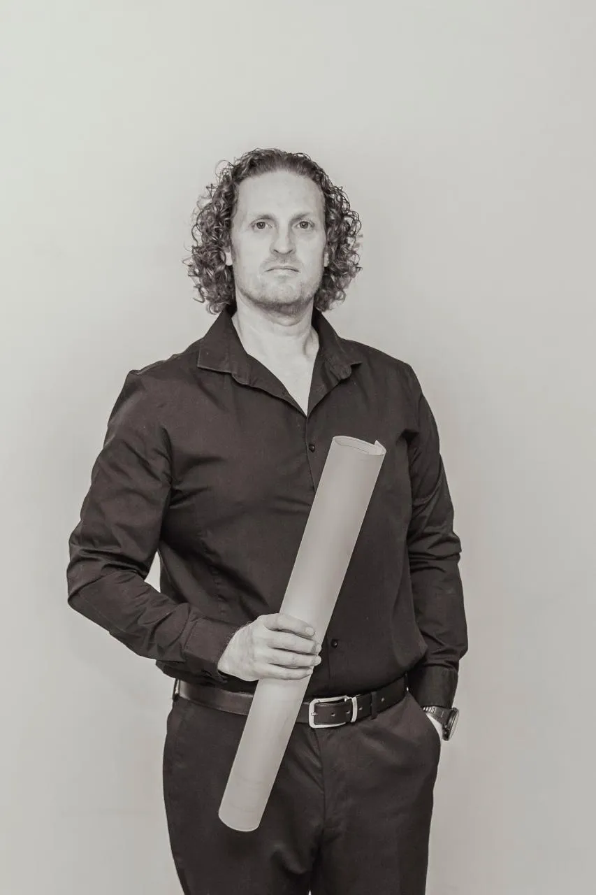 Sean Westraad, founder of Renov8, holding a set of architectural plans